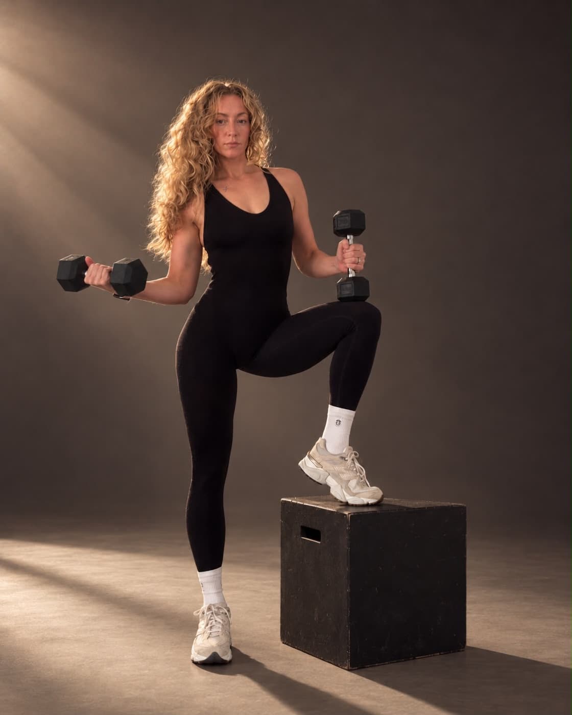 Kate training with dumbbells, one foot on a box